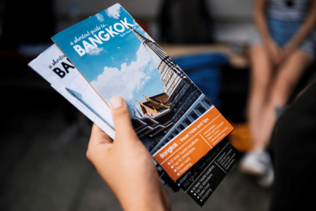 closeup-of-hand-holding-bangkok-travel-guide-broch-2023-11-27-04-51-08-utc